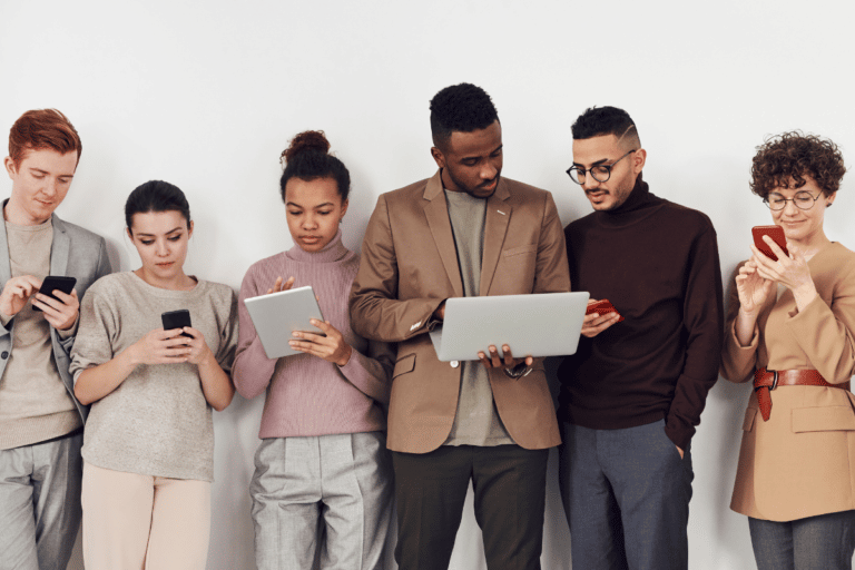 diverse group of young professionals looking at devices