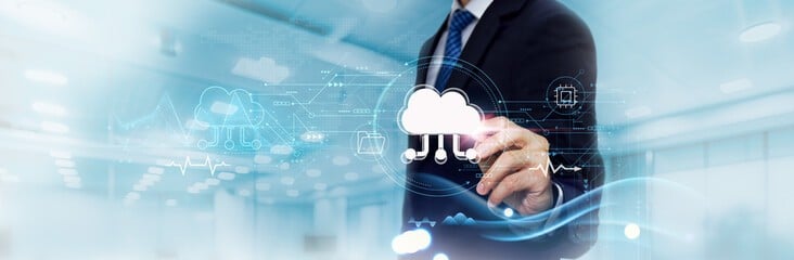 Businessman in a suit touches a floating cloud icon amid digital data visuals, illustrating cloud computing.
