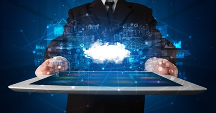 Businessperson in a suit holds a tablet emitting a glowing cloud computing hologram